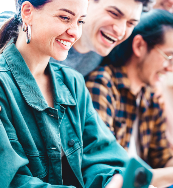A group of smiling young professionals looking at a laptop together