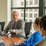 An older man gestures with his prosthetic hand
